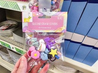 person holding a pack of 6 silicone straw toppers