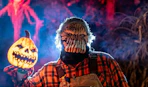 a monster holding a glowing pumpkin outside