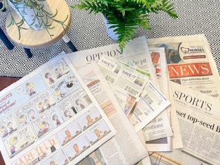 sunday newspaper laid out on table