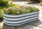 a garden bed with flowers in it on a walkway