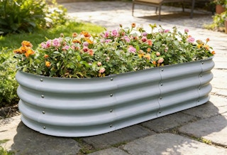 a garden bed with flowers in it on a walkway